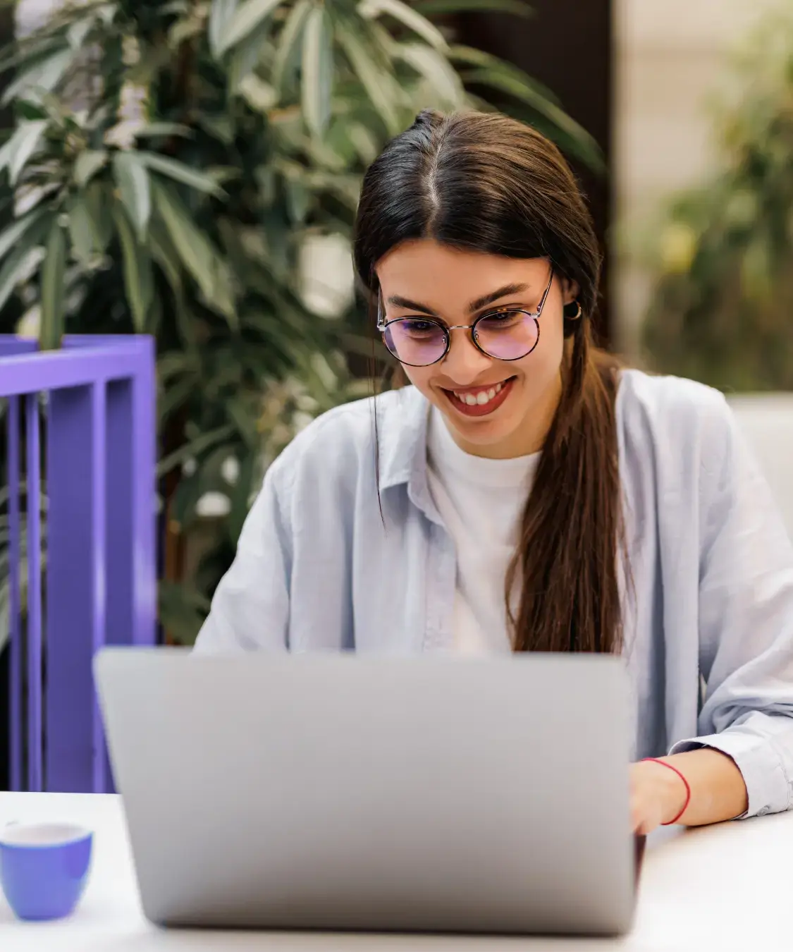 a woman smiling at a laptop