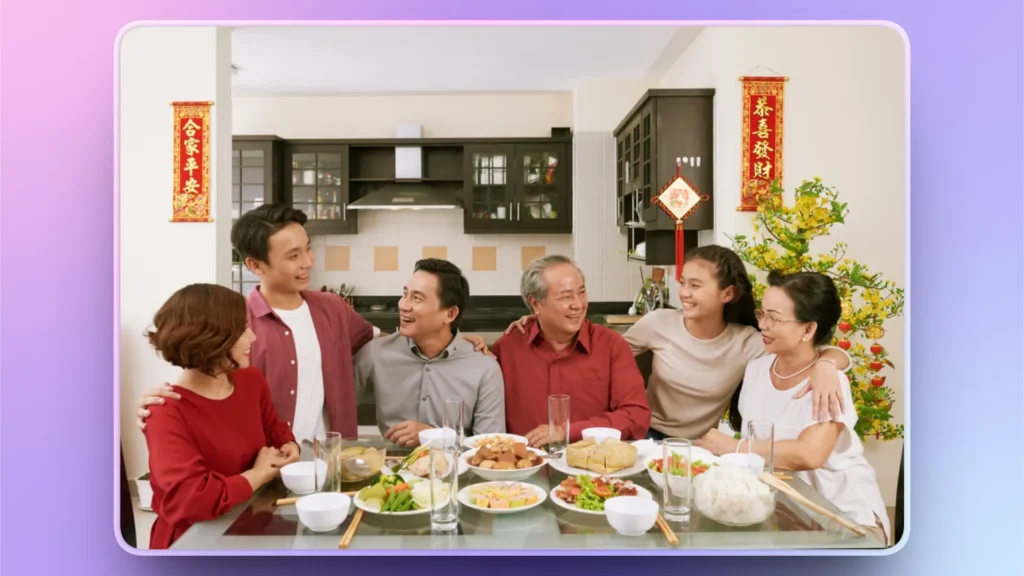 Multigenerational Asian family sharing a meal at a dining table with festive decorations.