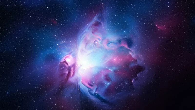 Vibrant purple and blue nebula surrounded by numerous bright stars in deep space.