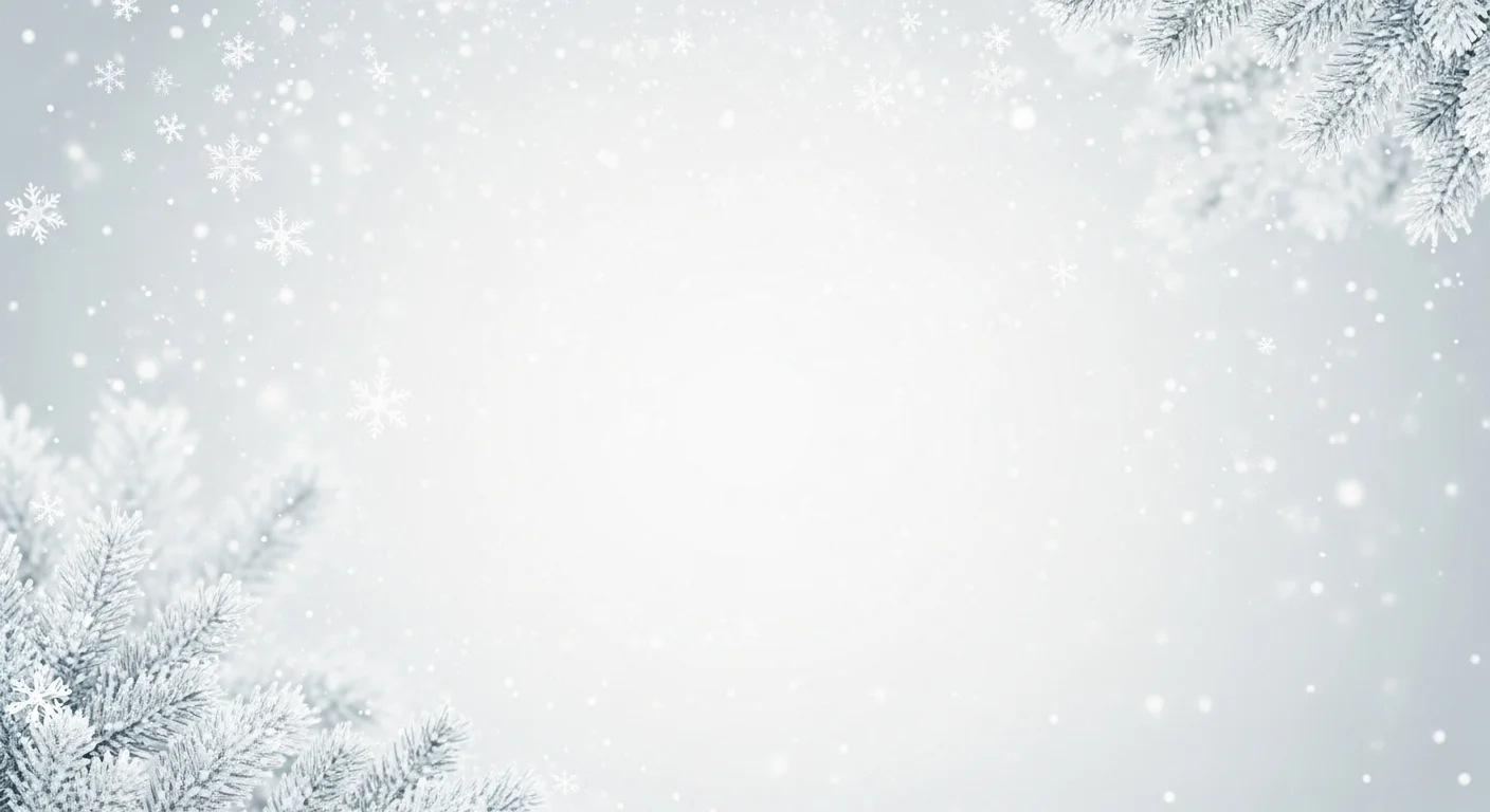 Frosted pine branches with falling snowflakes on a soft gray winter background.