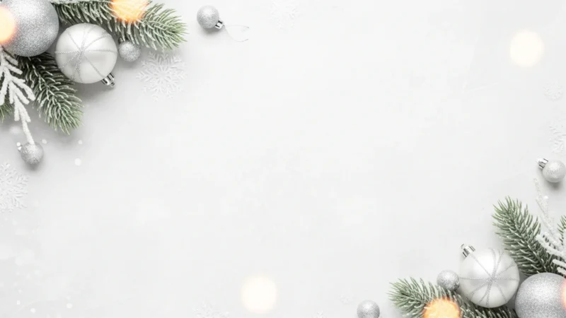 Festive silver and white Christmas ornaments with frosted pine branches on white background.