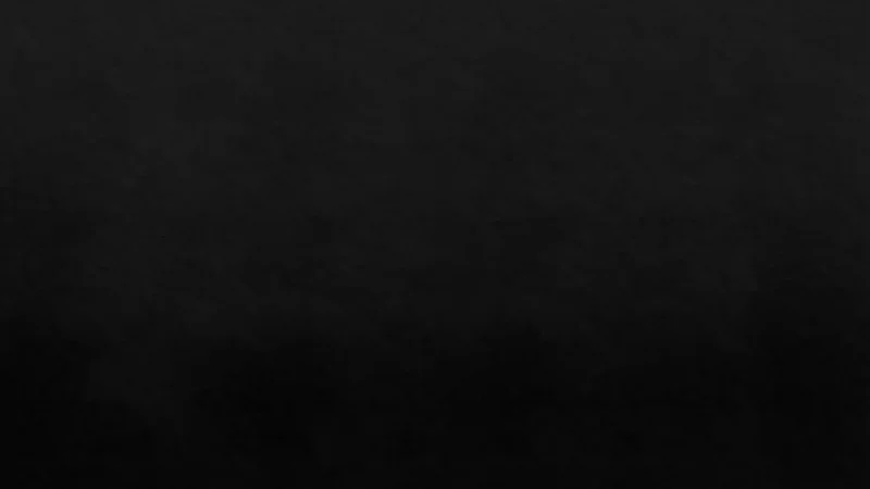 Black textured background with subtle gradient shading and no visible objects or text.