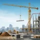 Construction site with yellow crane lifting steel beam, excavator, and workers on concrete building.