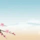 Delicate pink cherry blossoms on a branch with misty mountains and clear sky background.