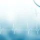 Blue stethoscopes and white electrocardiogram lines on a light medical-themed background.