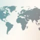 World map illustration with continents in gradient shades of blue and gray on a light background.