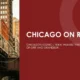 Elevated Chicago L train traveling through dense urban area with tall buildings.