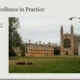 Historic collegiate gothic architecture with expansive green lawn and grazing cows.