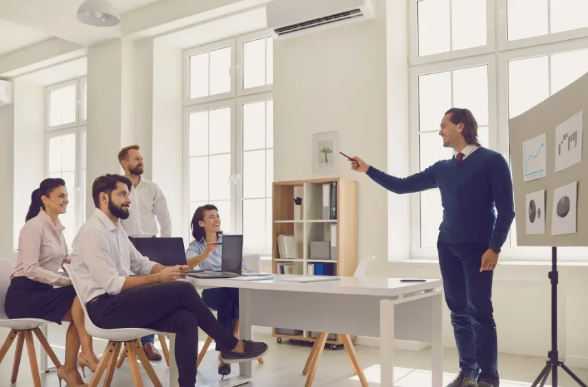 Business professional giving presentation to colleagues in a bright modern office.